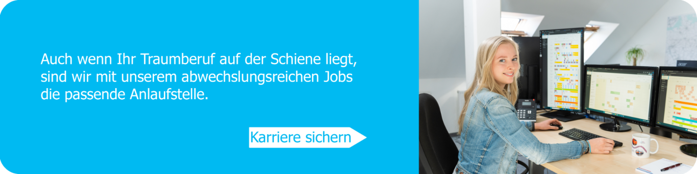 Frau sitzt an einem Schreibtisch mit mehreren Monitoren und arbeitet konzentriert.